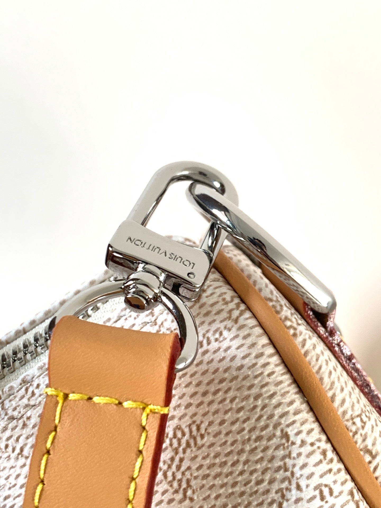 Louis Vuitton bag hardware with silver clasp and tan leather strap on textured lining