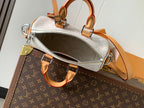 Louis Vuitton handbag interior view with silver zipper, tan handles and white monogram canvas