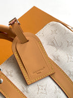 Louis Vuitton leather luggage tag-style patch on light fabric strap with tan edging