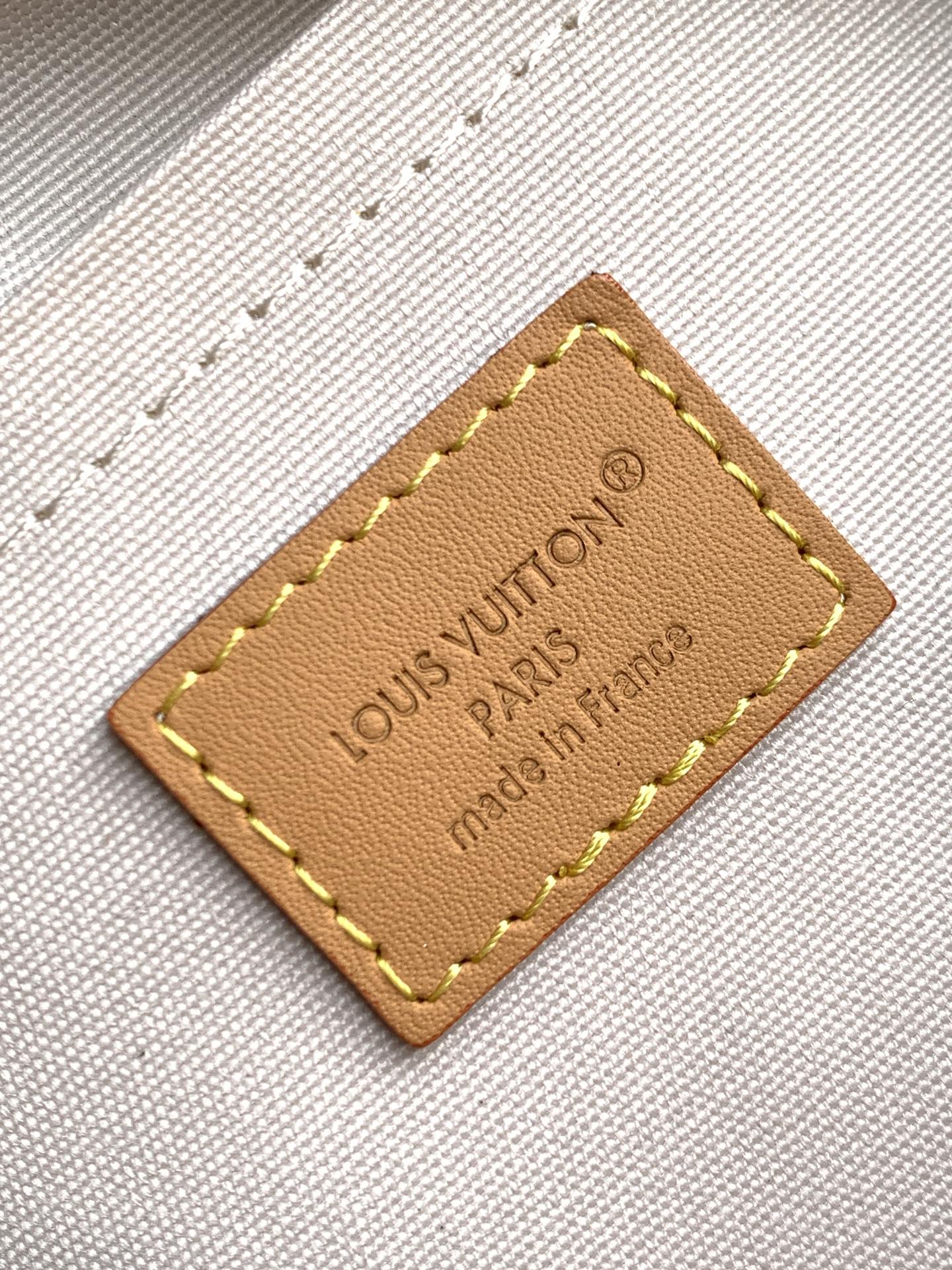 Louis Vuitton leather label patch with stitched border on white textured fabric