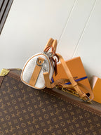 Louis Vuitton mini handbag with white monogram canvas, tan leather trim and side hardware