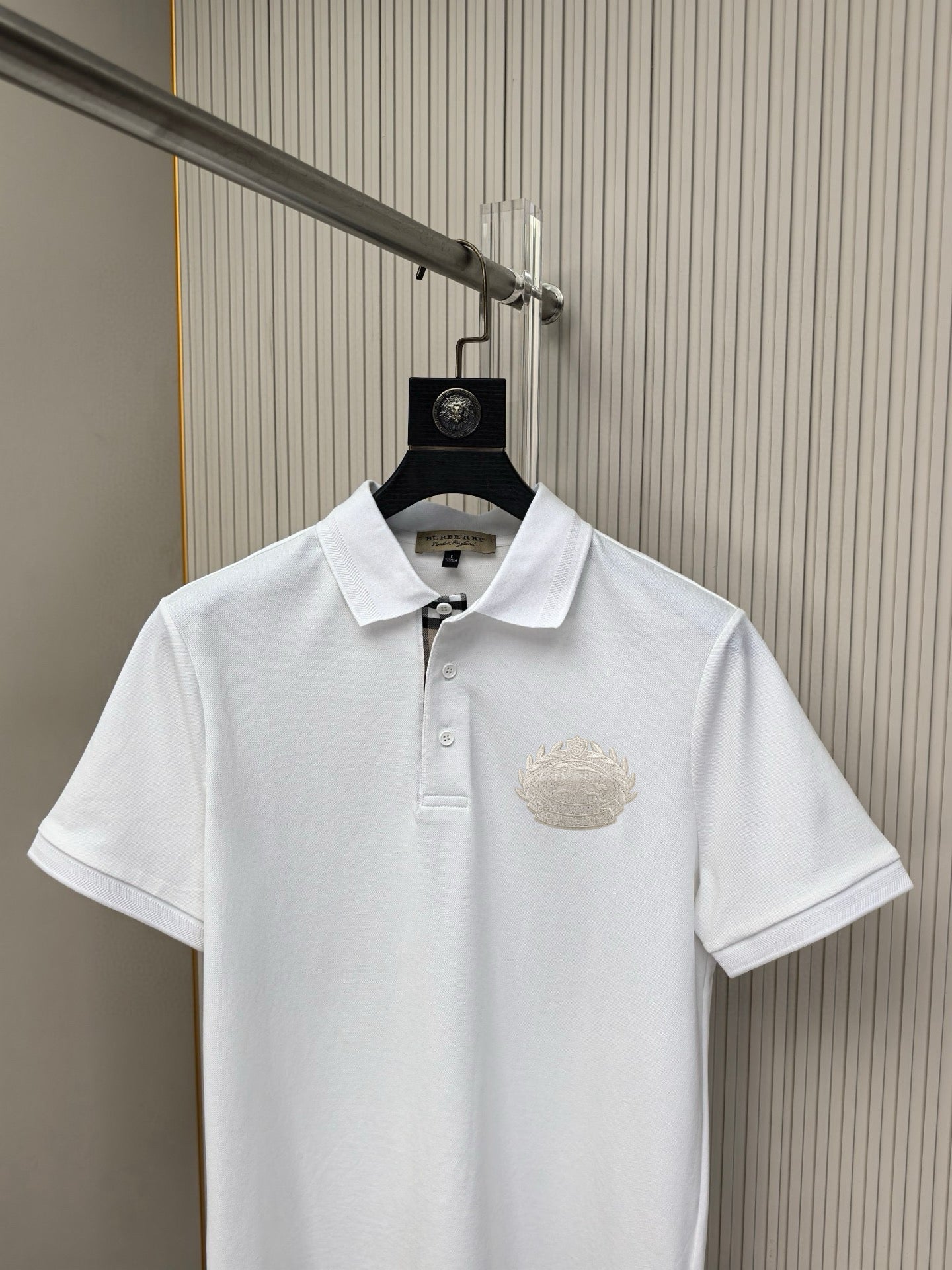 White Burberry polo shirt front view with chest crest logo and button placket