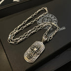 Two silver-tone chain necklaces with rectangular pendant on black display