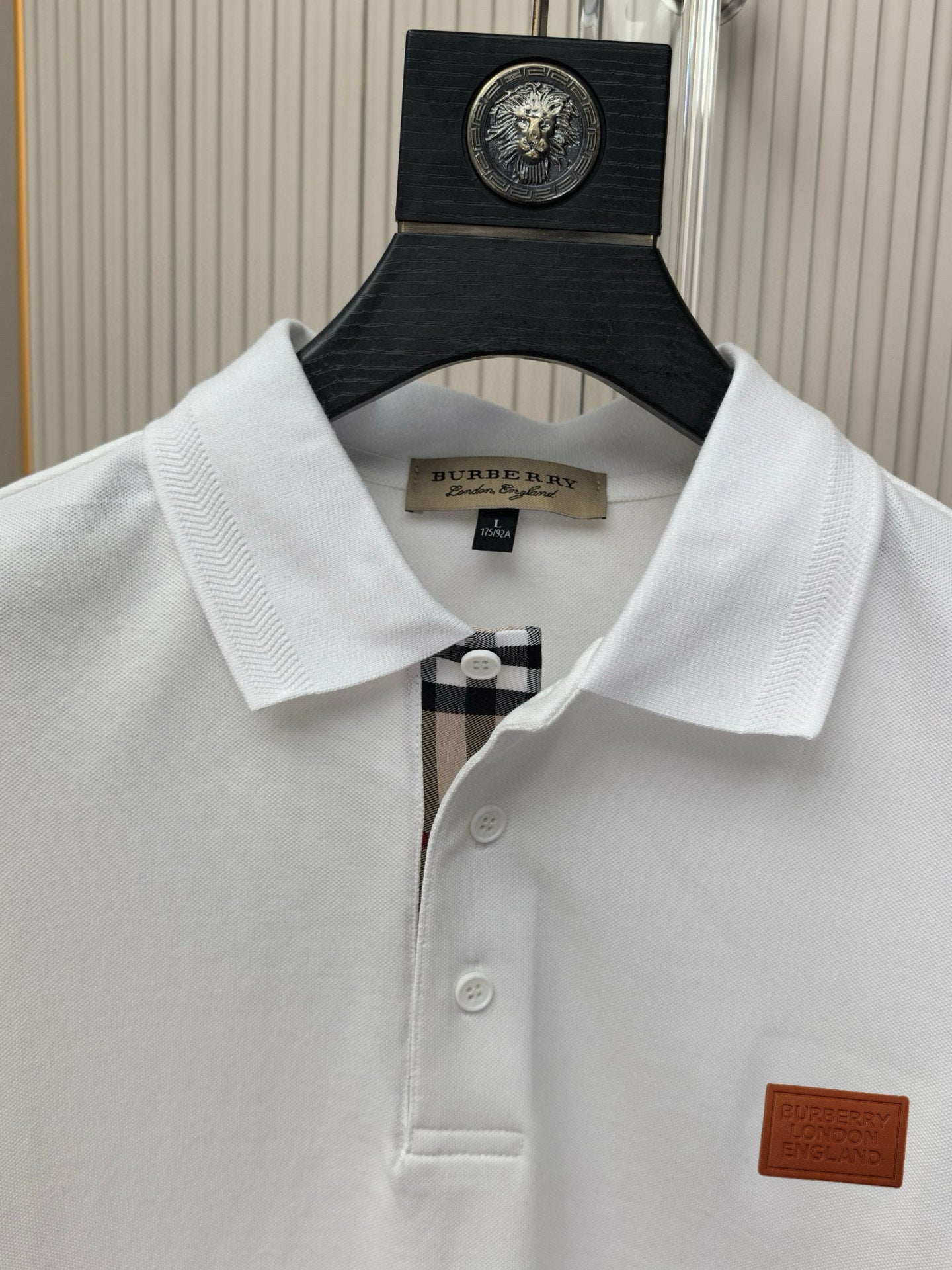 White polo shirt collar and button placket with logo patch