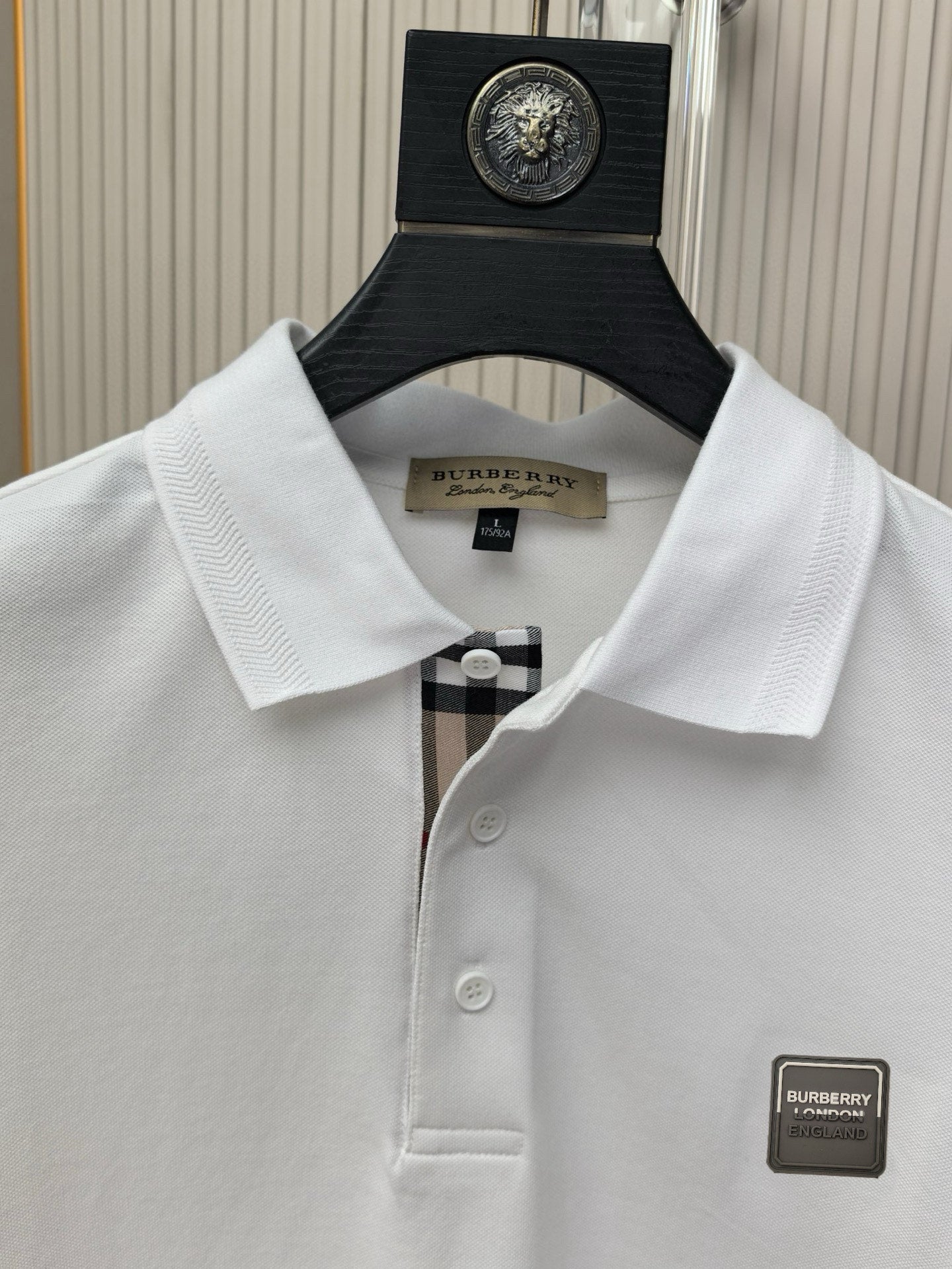 White polo shirt collar and button placket with Burberry logo patch