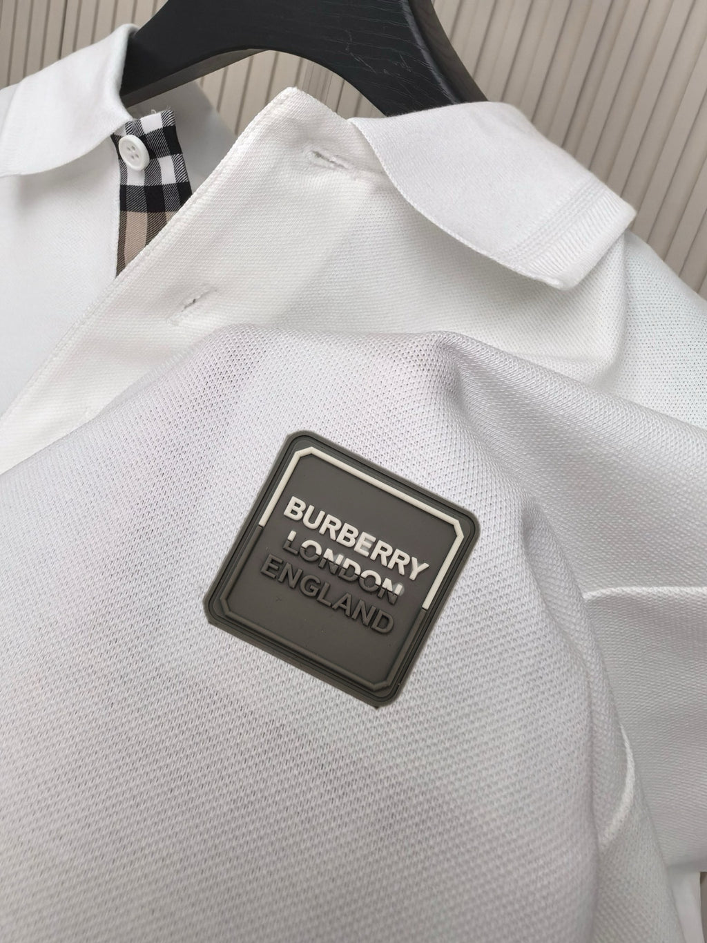 White polo shirt fabric with Burberry England logo patch
