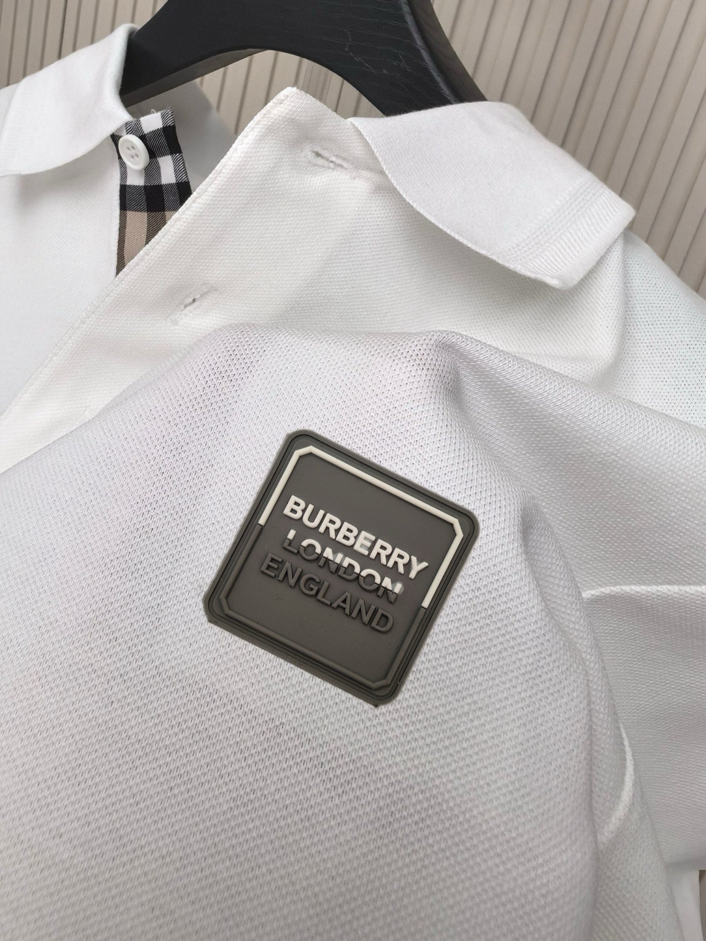 White polo shirt fabric with Burberry England logo patch