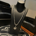 Silver-tone chain necklace with small square pendant, shown on a black necklace stand