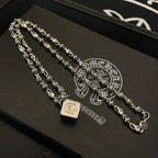 Silver-tone chain bracelet set with square and star-like charms on a dark tray