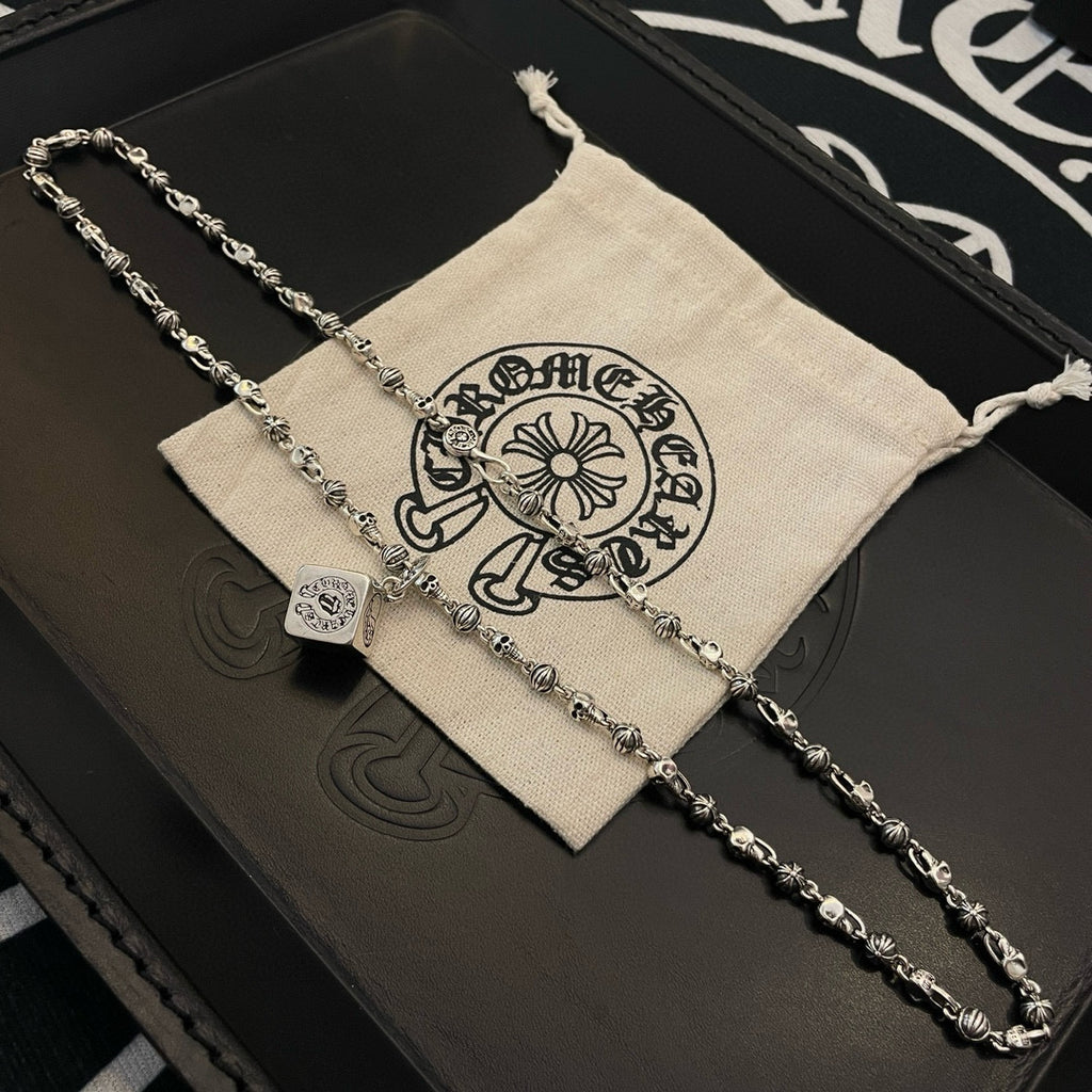 Silver tone chain necklace with cube pendant charm on jewelry box