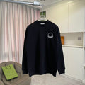 Black long-sleeve sweatshirt with small circular Moncler logo on chest