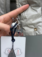 Light gray puffer jacket with dangling keyring tag and zipper hardware