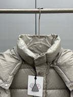 Light gray hooded puffer jacket close-up with front snap buttons and tag