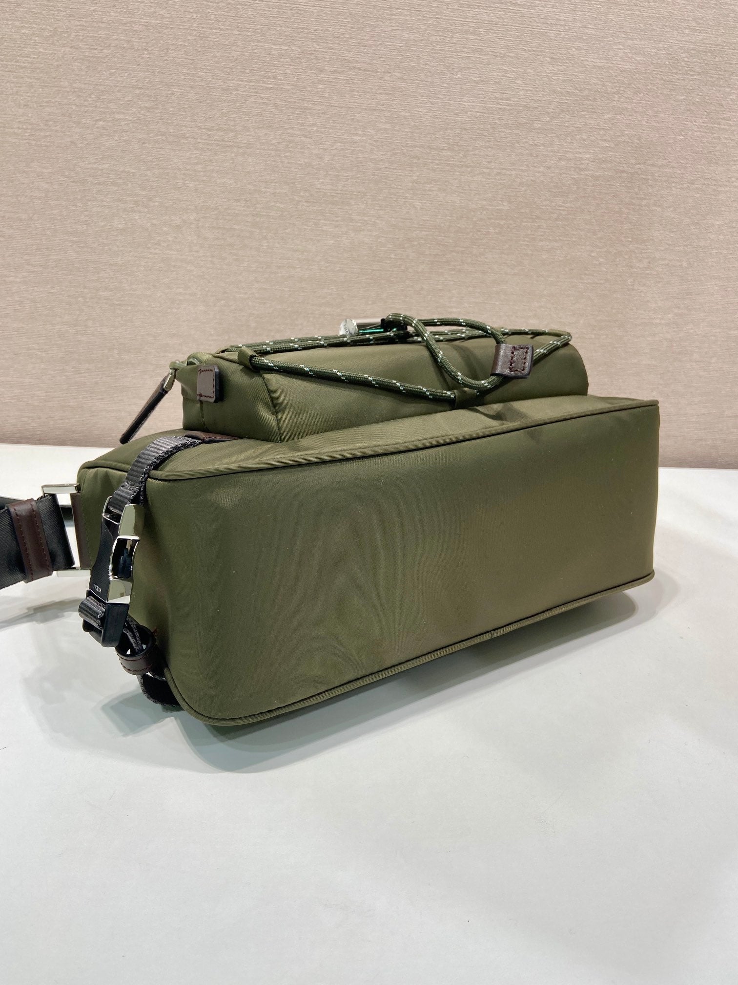 Olive Prada bag with top handle and multiple straps, shown from the side