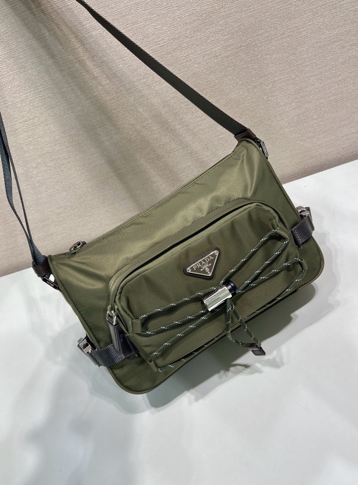 Olive Prada crossbody bag with long strap, quilted front, and flap front