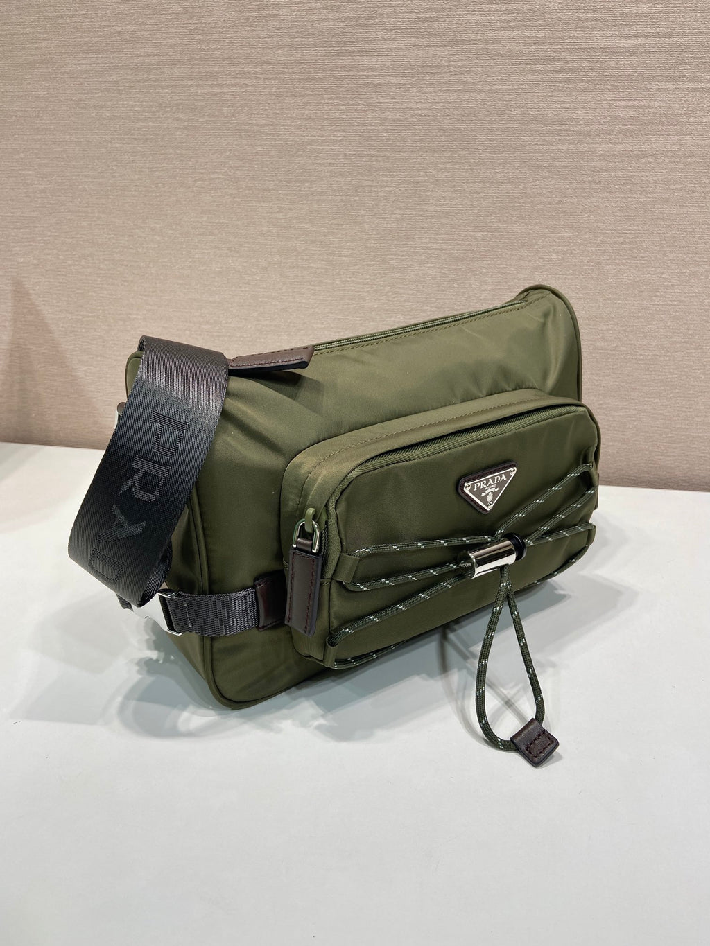 Olive Prada crossbody bag with front pocket, quilting, and adjustable shoulder strap