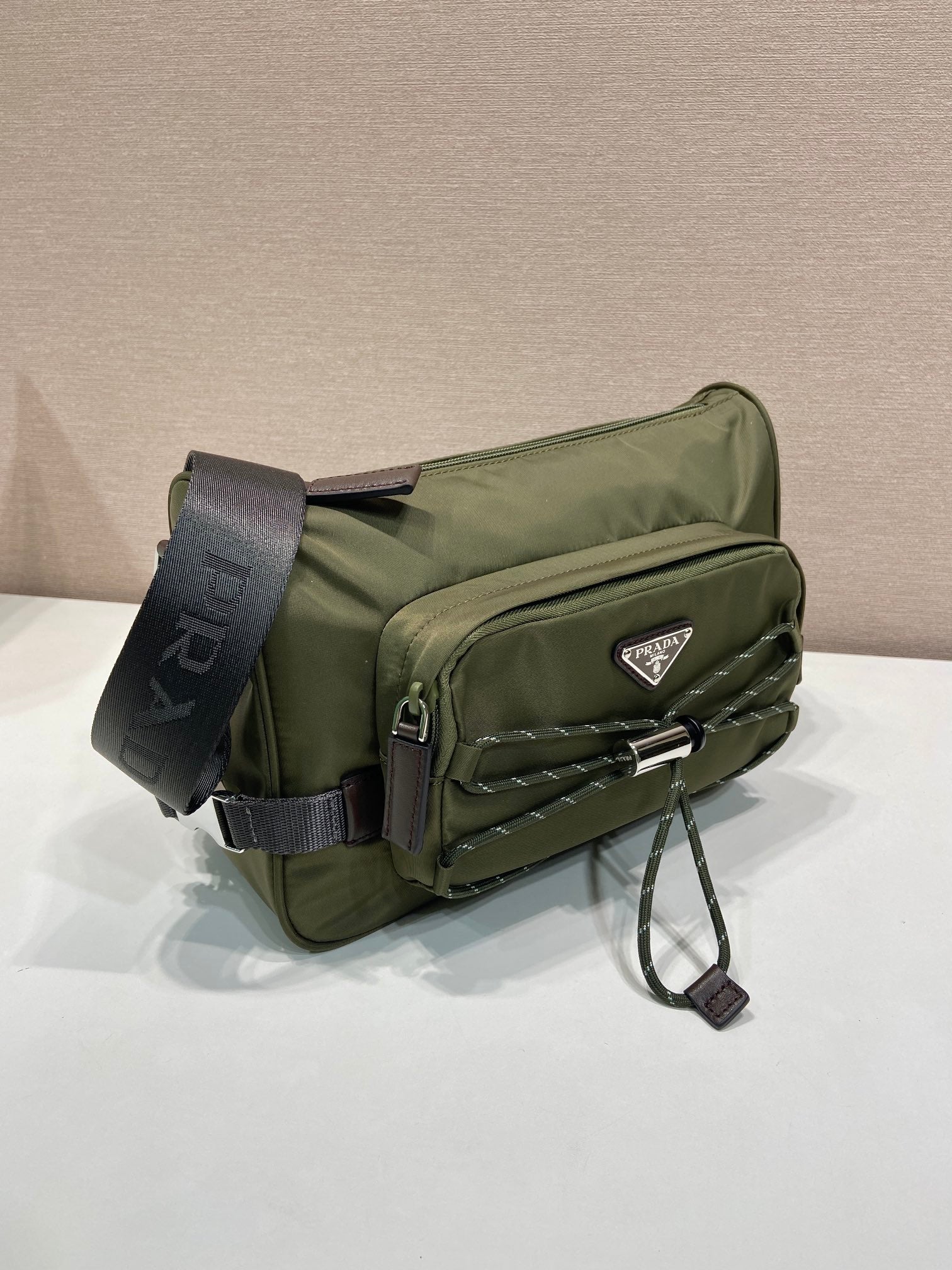 Olive Prada crossbody bag with front pocket, quilting, and adjustable shoulder strap