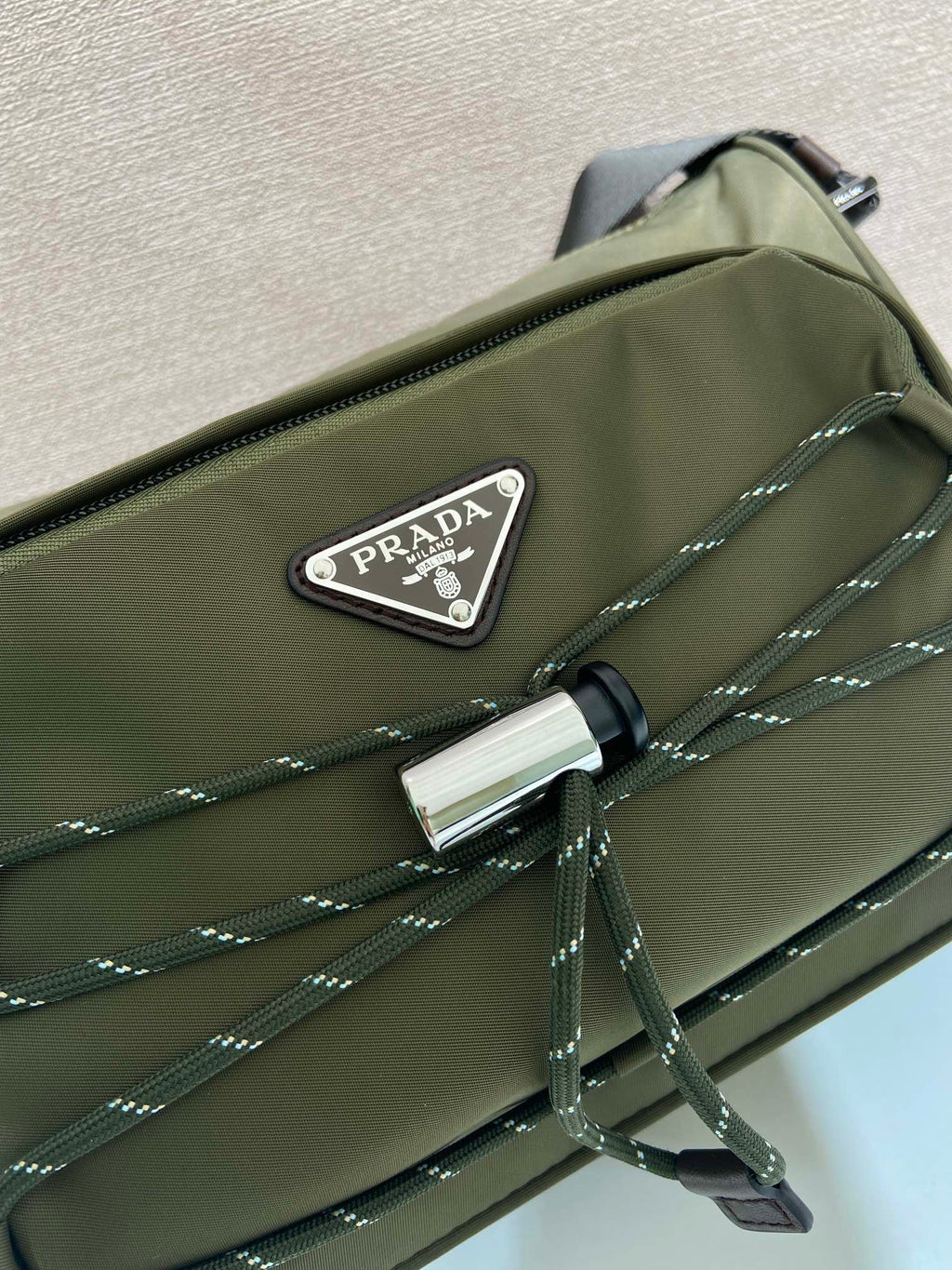 Olive Prada bag front with PRADA logo patch and silver clasp