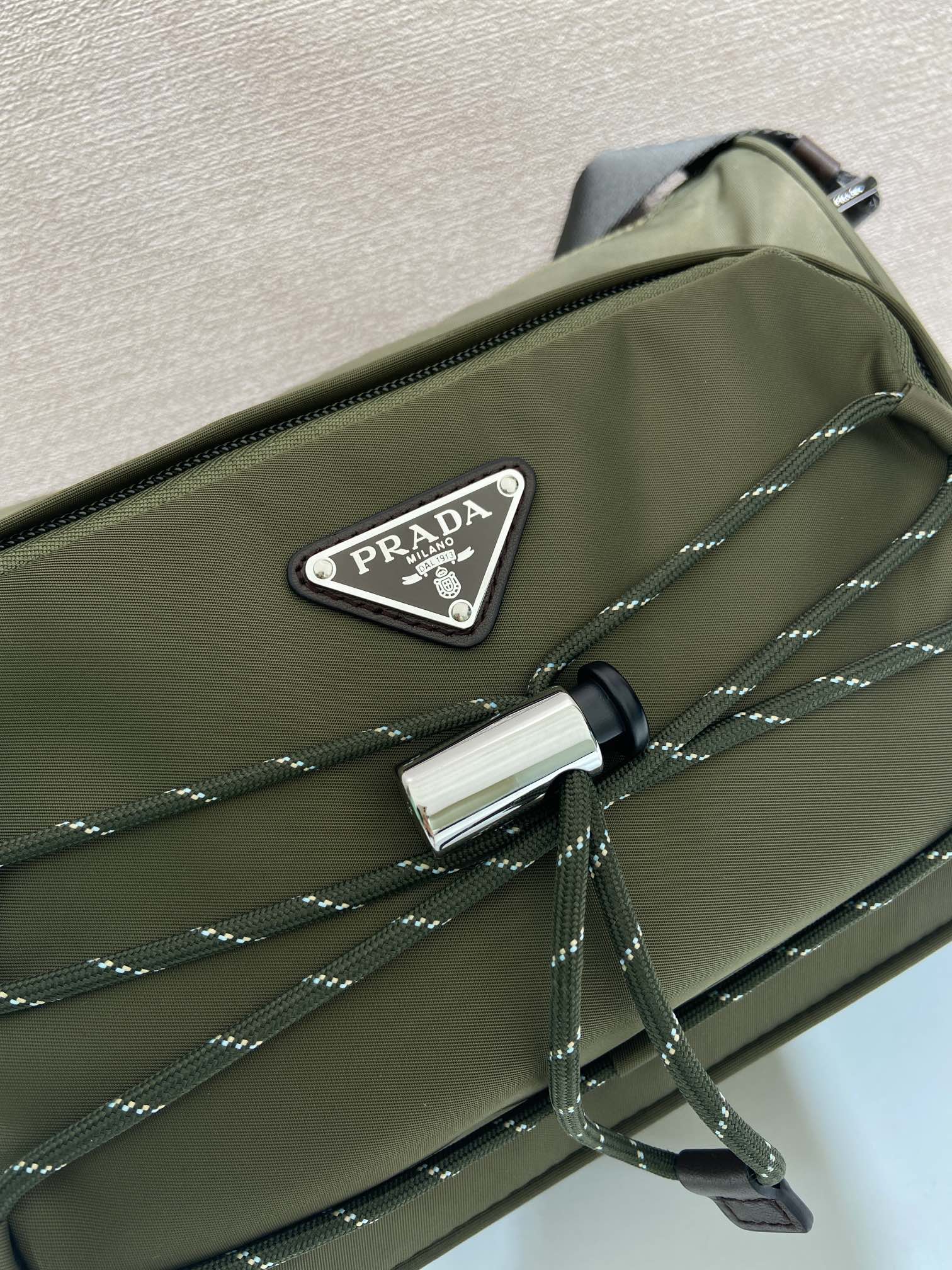 Olive Prada bag front with PRADA logo patch and silver clasp