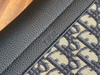 Black Dior leather panel with embossed Dior text on textured strap.