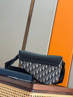 Navy Dior crossbody bag with flap and Dior-oblique patterned front panel.