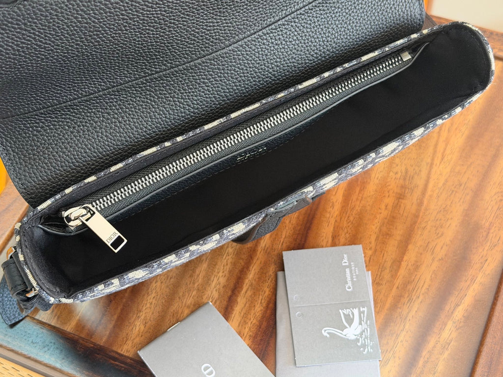 Black Dior crossbody bag with top zipper opening and smooth interior lining.