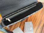 Black Dior crossbody bag with top zipper opening and smooth interior lining.