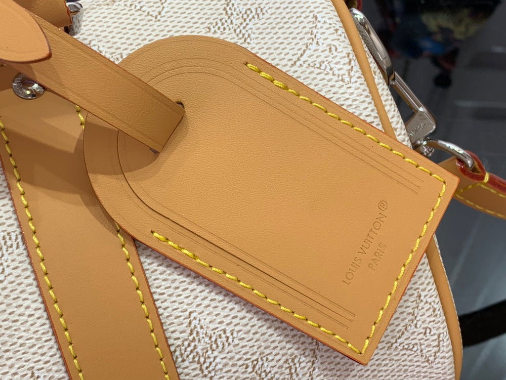 Louis Vuitton duffel bag leather trim with stitched edge and metal hardware, close-up