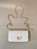 White quilted leather Chanel flap bag with gold chain shoulder strap and CC logo.