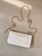 White quilted Chanel flap bag with gold chain shoulder strap and CC logo front.
