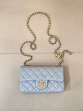 Light blue quilted flap shoulder bag with gold chain and gold logo medallion