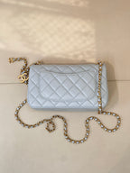 Light blue quilted flap shoulder bag with gold chain strap and gold logo hardware