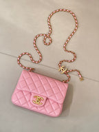 Pink quilted Chanel mini flap bag with gold-tone logo and chain shoulder strap