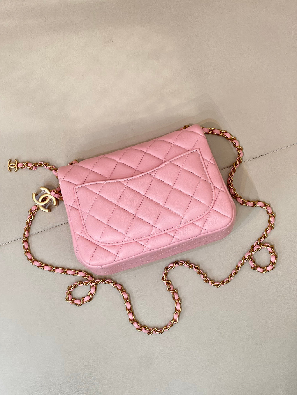 Pink quilted Chanel flap crossbody bag with gold-tone logo and braided chain strap