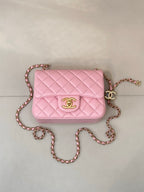 Pink quilted Chanel crossbody flap bag with gold-tone logo and long chain