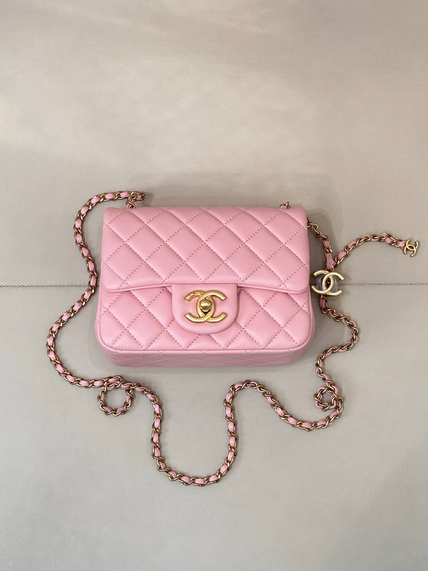 Pink quilted Chanel crossbody flap bag with gold-tone logo and long chain