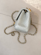 Chanel quilted bag side view, light blue leather with gold chain strap