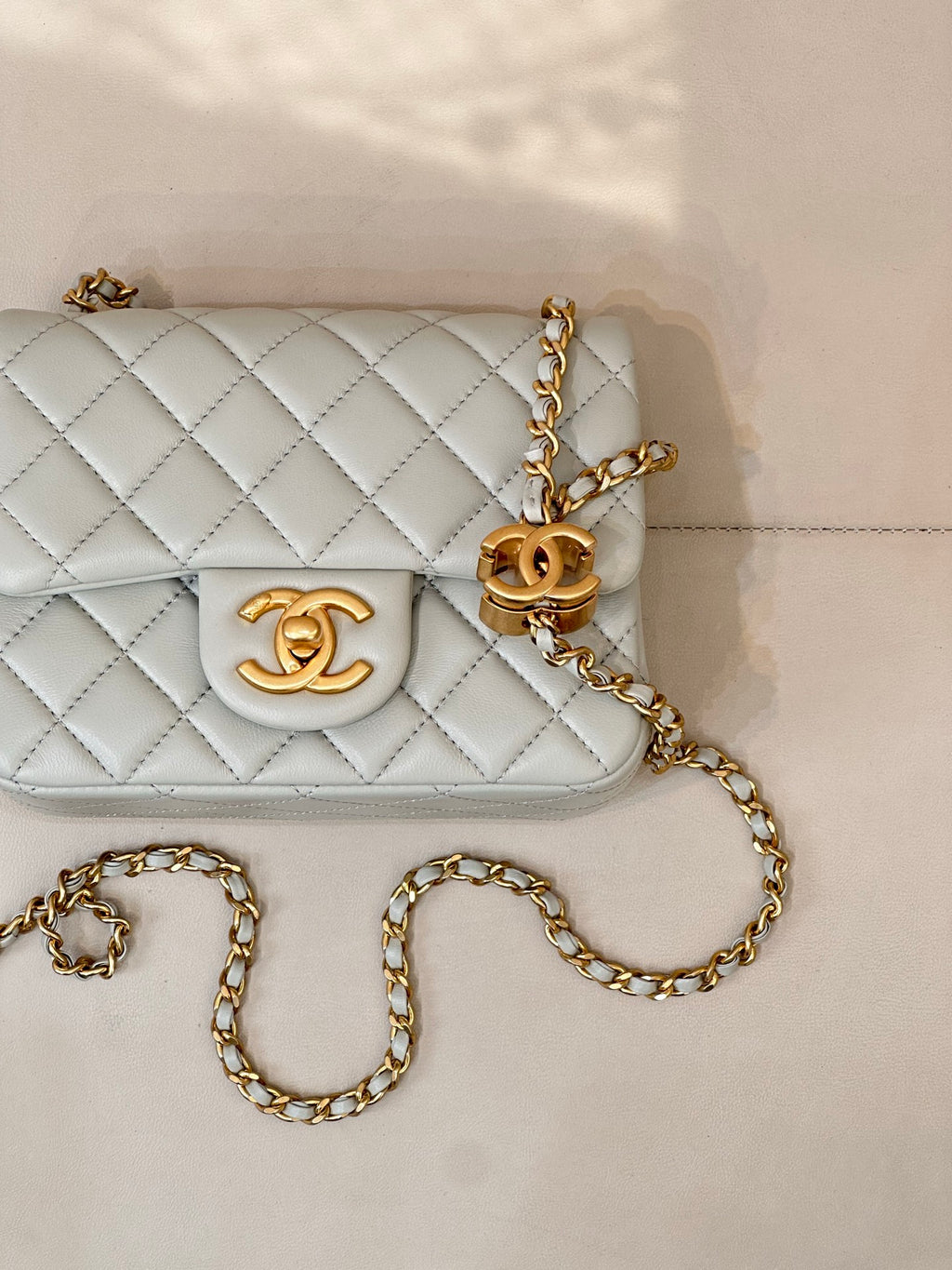 Chanel quilted shoulder bag detail, light blue flap with gold CC logo and chain