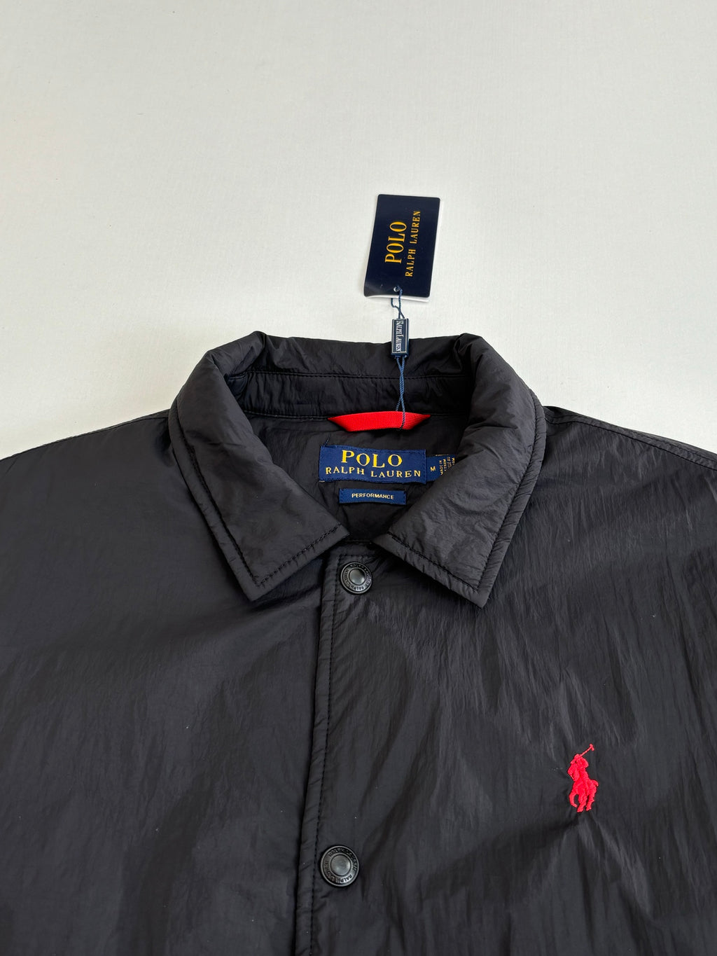 Black button-up jacket with stand collar and red polo pony logo