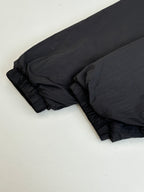 Black puffer jacket sleeve and hem with gathered stitching