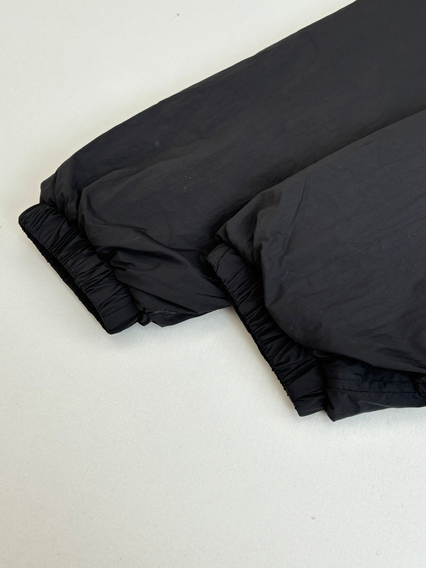 Black puffer jacket sleeve and hem with gathered stitching