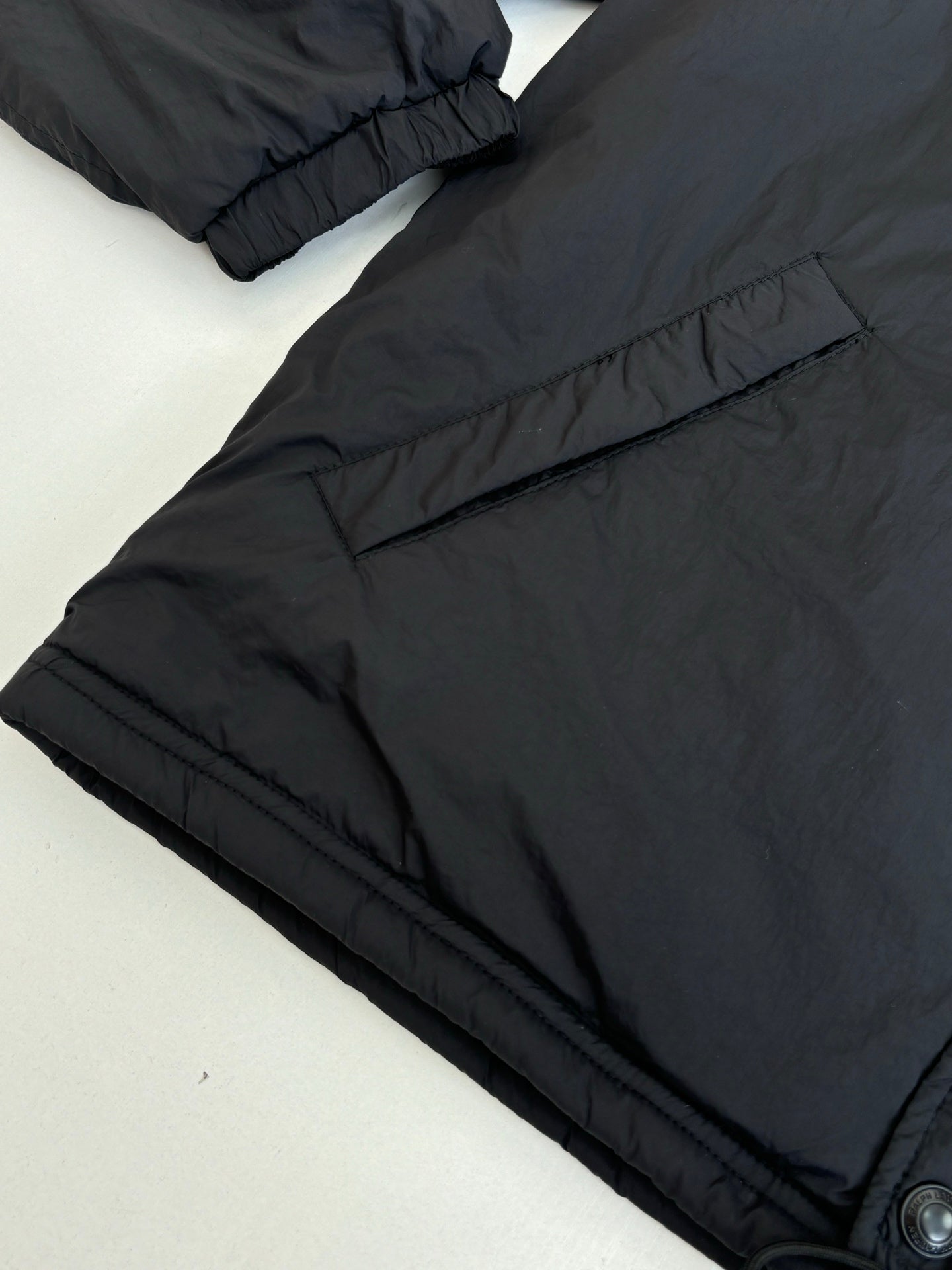 Black puffer jacket with elastic cuff and stitched seam details