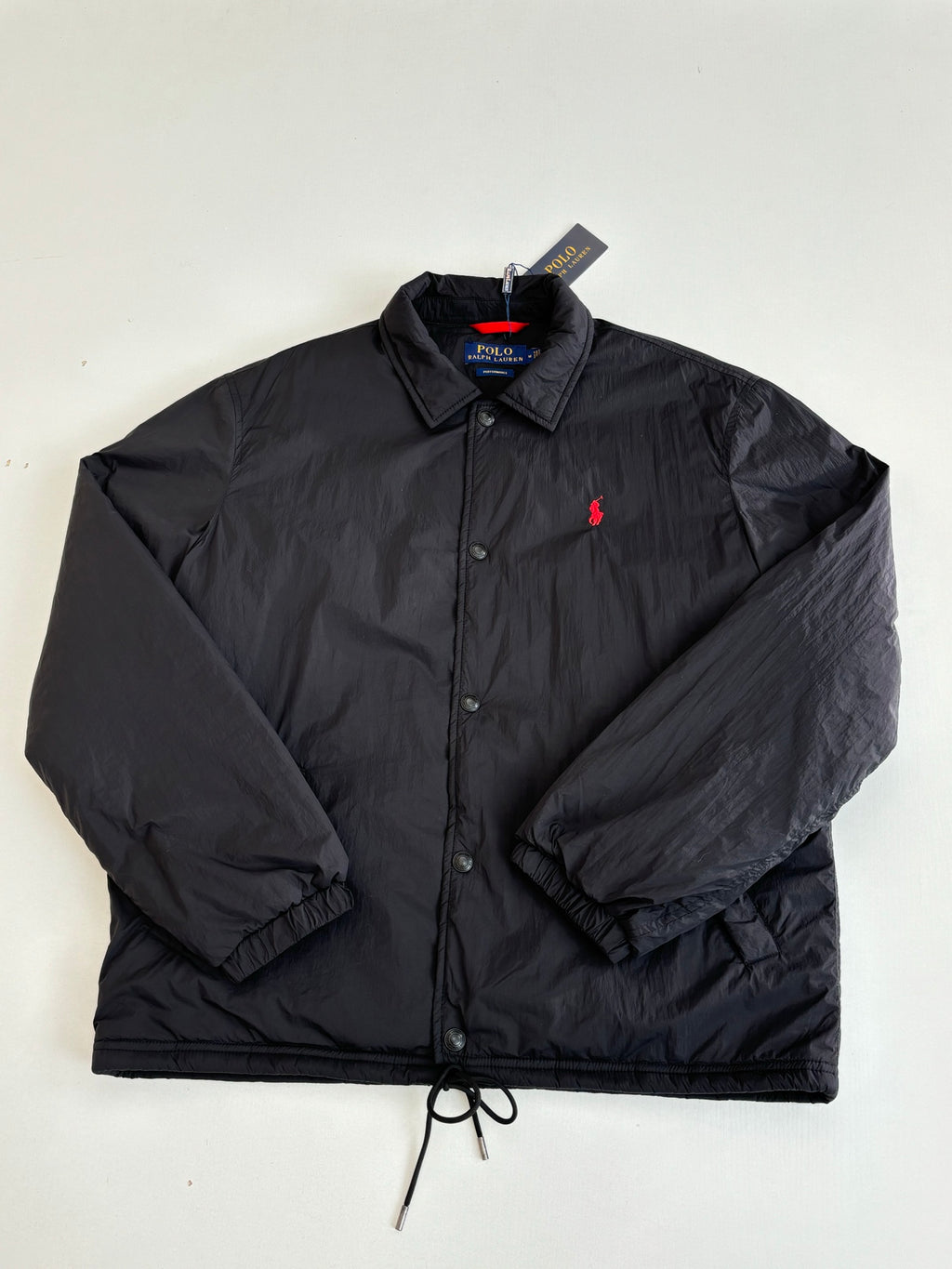 Black nylon jacket with red polo logo, button front, and stand collar