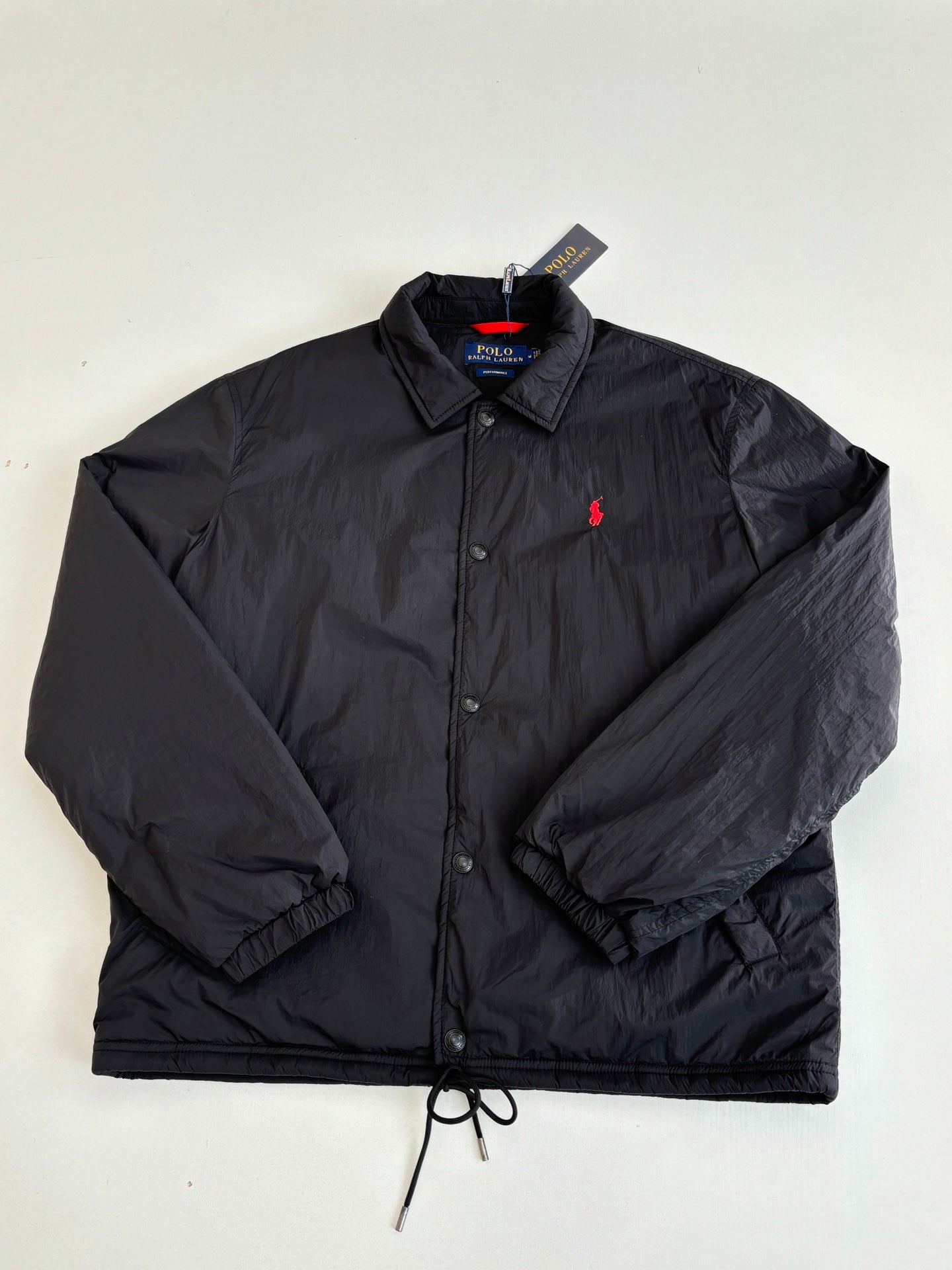 Black nylon jacket with red polo logo, button front, and stand collar