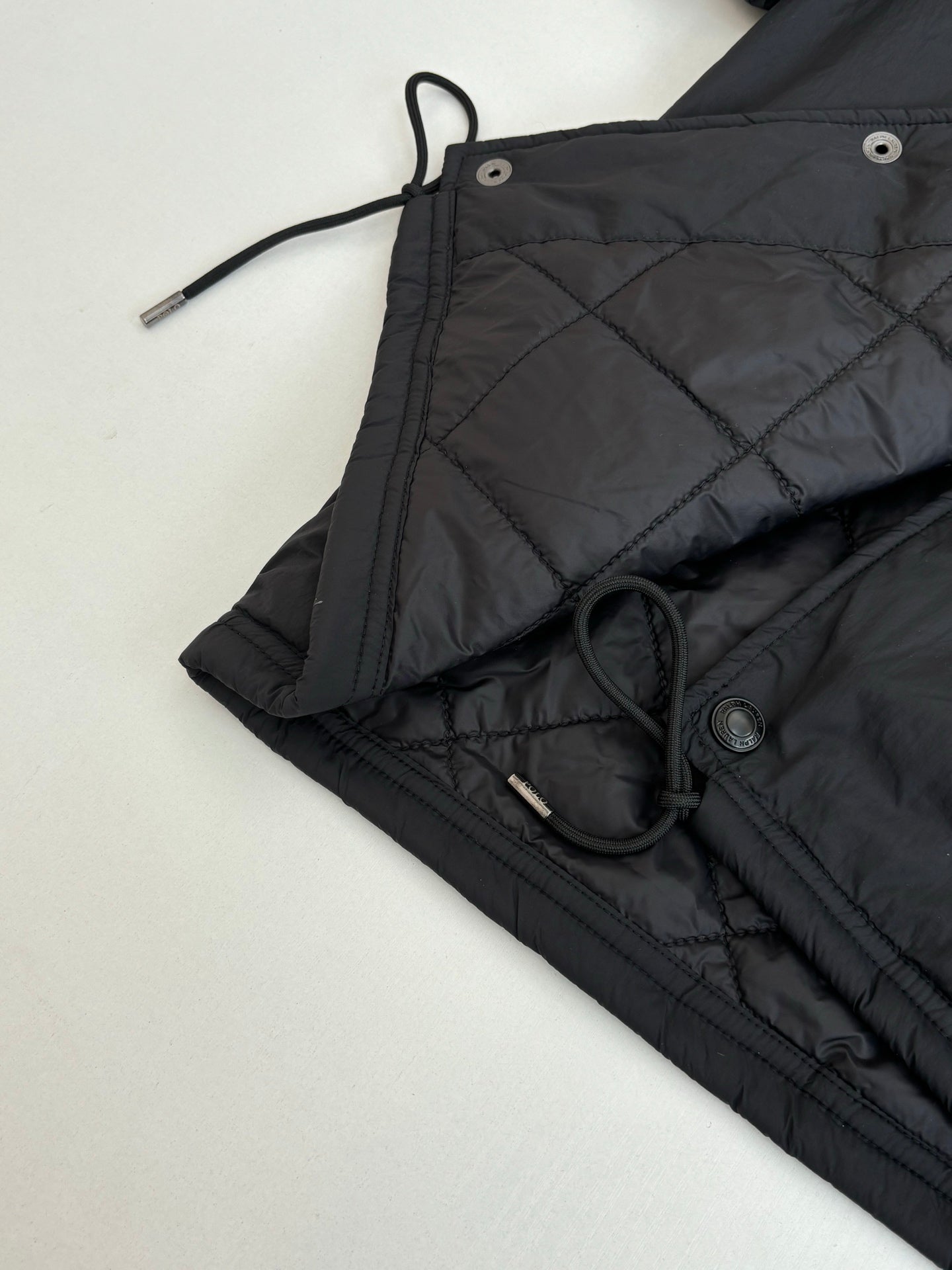 Black jacket with drawstring ties and metal button hardware