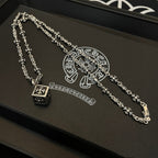 Silver floral-link necklaces on black box tray with pendant detail