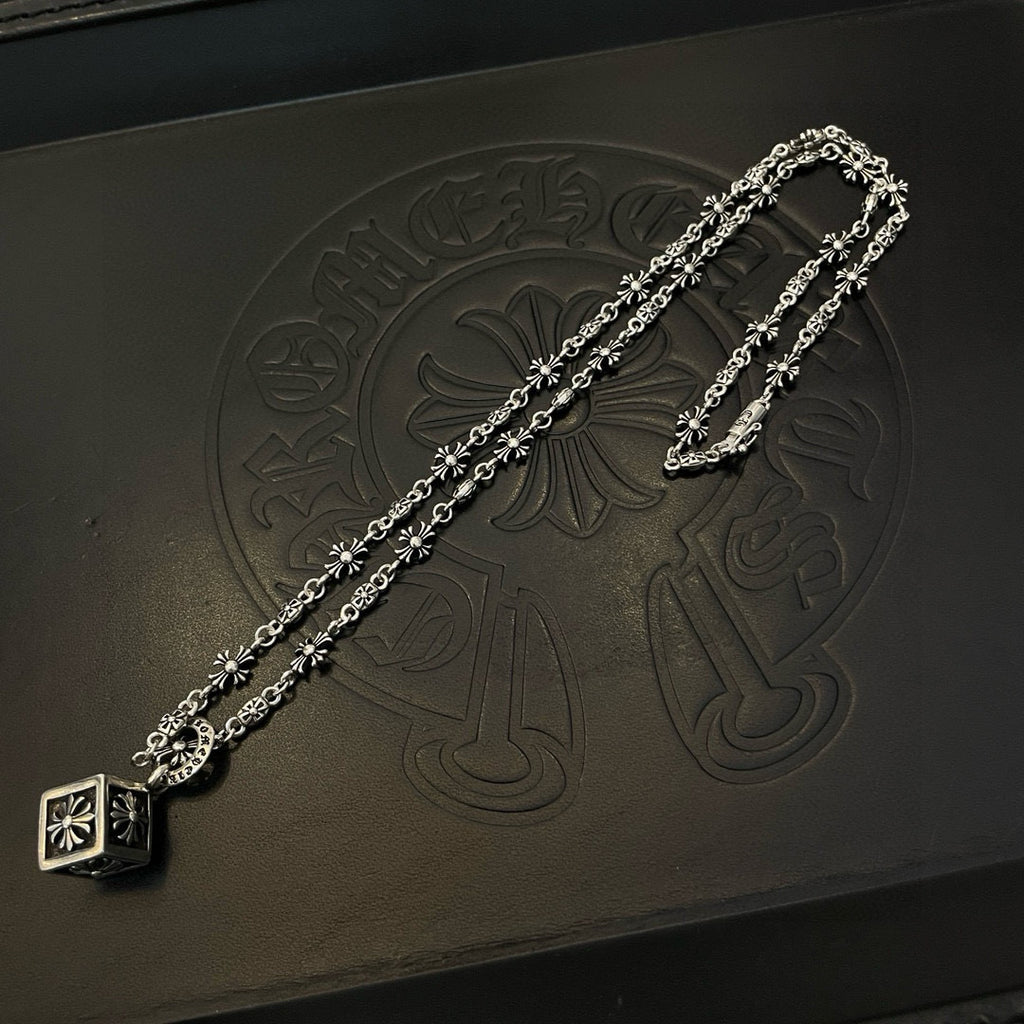 Silver floral chain necklace with square pendant on black accessory box