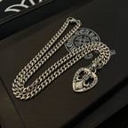 Silver-tone chain necklace with Chrome Hearts heart pendant on a black presentation case