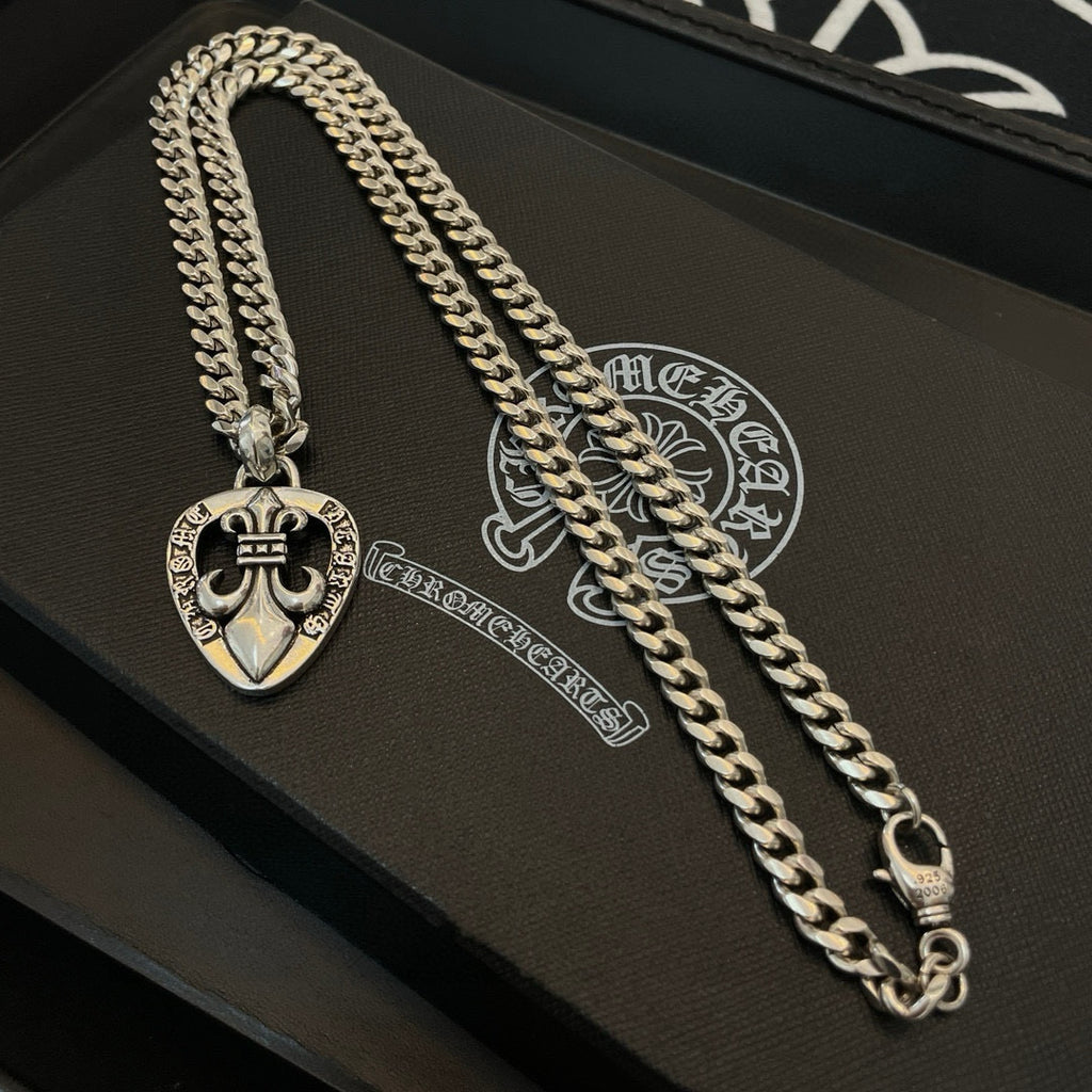 Silver-tone necklace chain with Chrome Hearts heart pendant, close-up on a case
