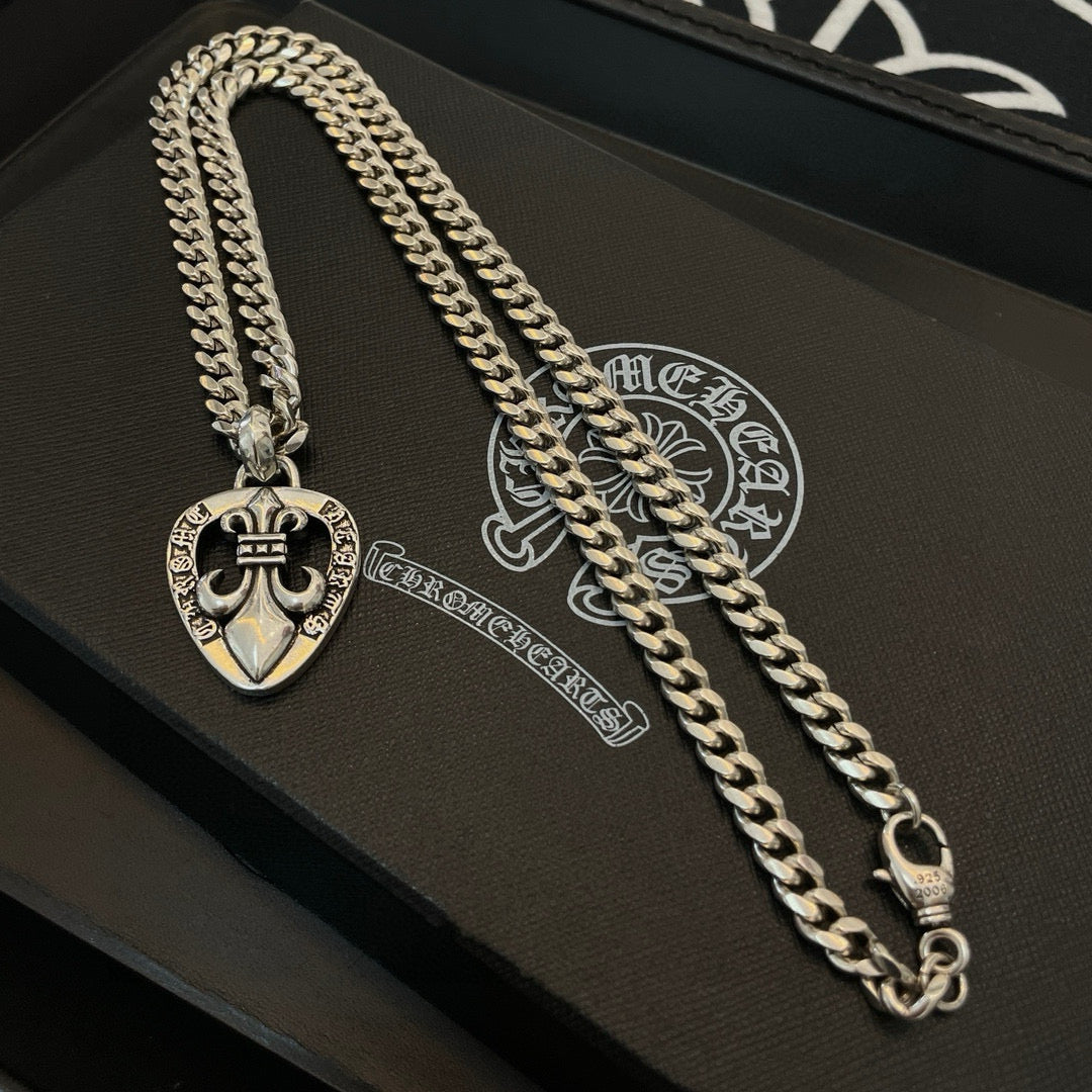 Silver-tone necklace chain with Chrome Hearts heart pendant, close-up on a case